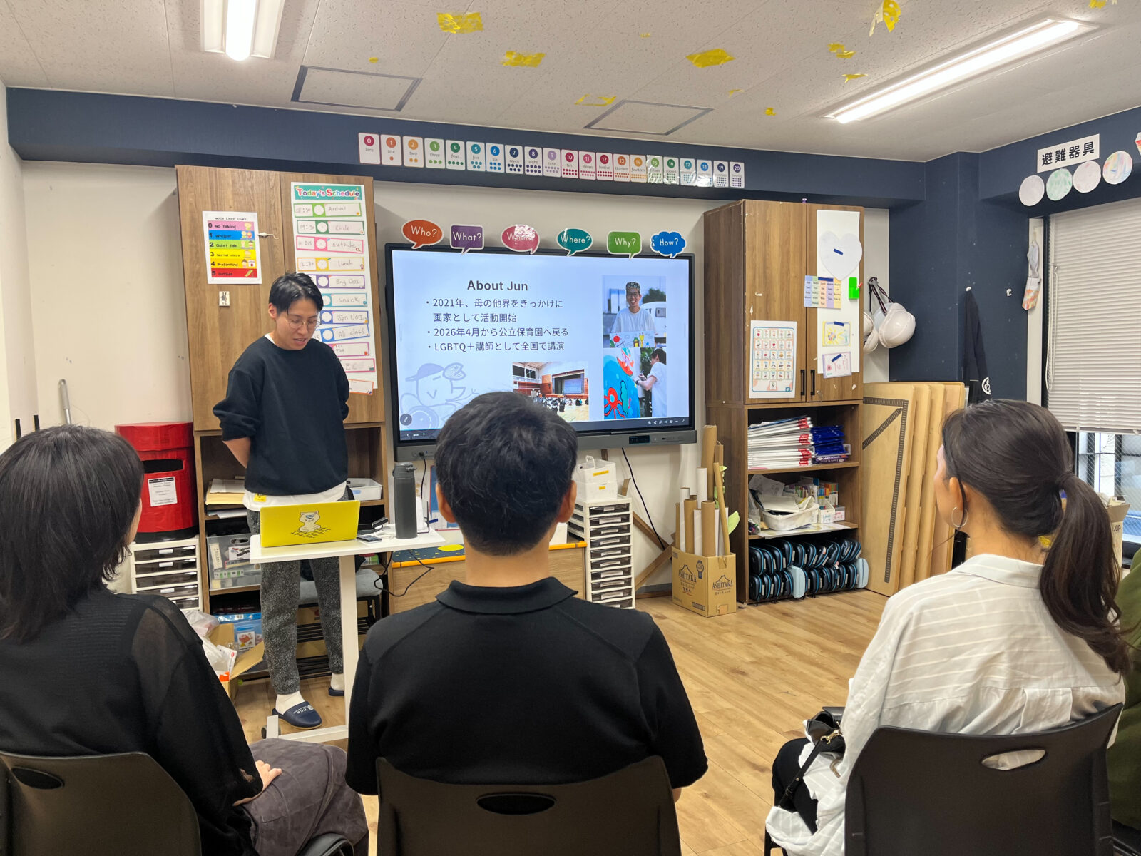 「About Jun」の自己紹介スライドを映しながら、保護者に話すMr. Jun