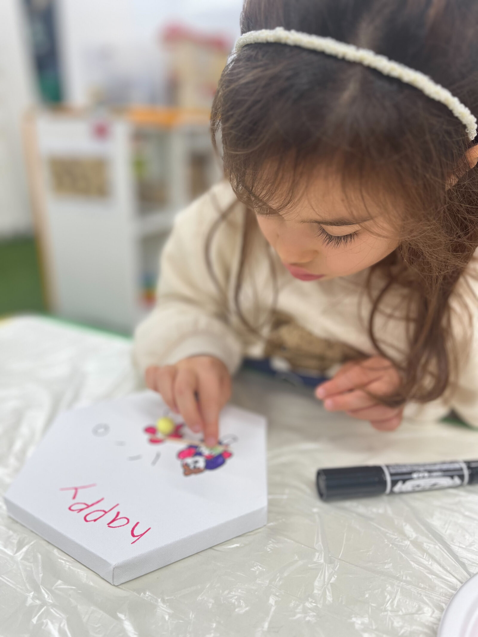 小さなパーツを選びながら作品を飾る子ども