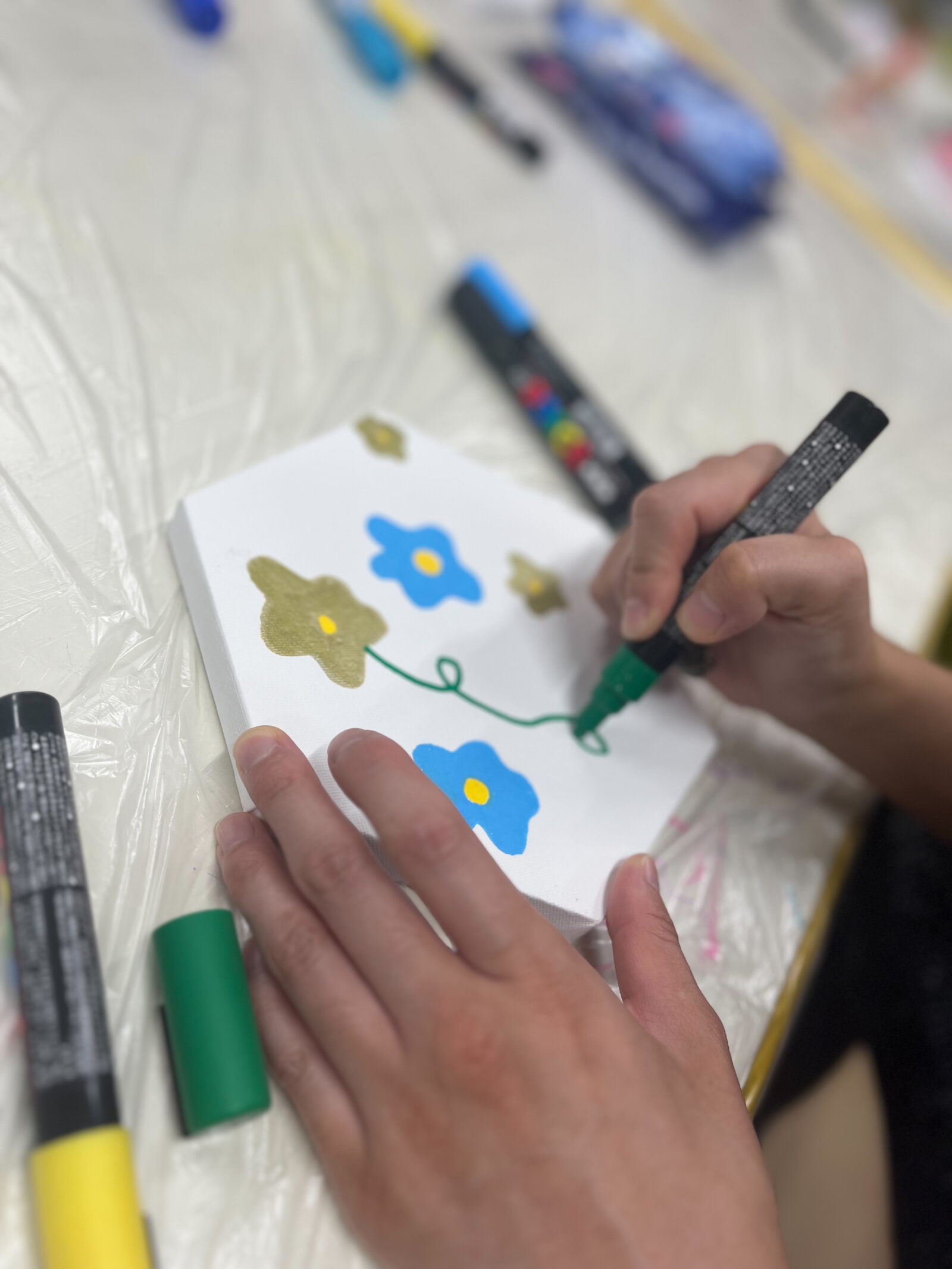 六角形のキャンバスに花を描く手元