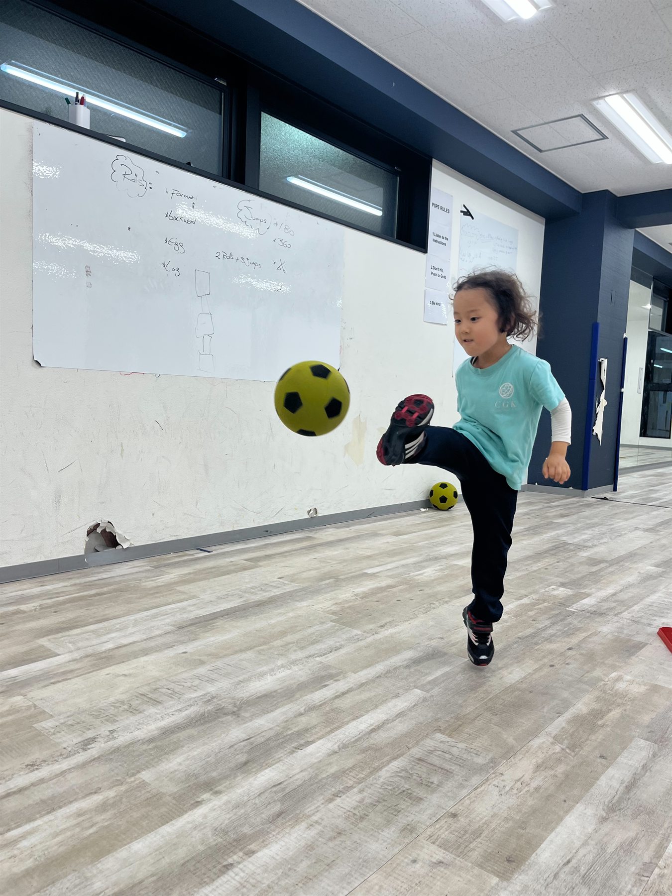 A child practicing kicking a soccer ball
